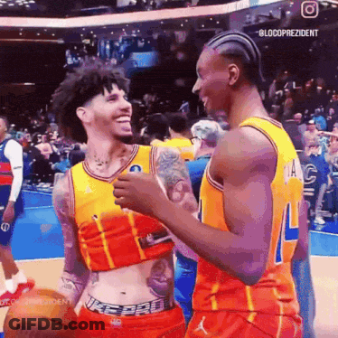 Two Basketball Players Are Hugging Each Other On The Court GIF