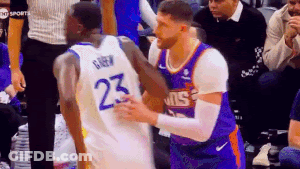 Two Basketball Players Are Hugging Each Other On The Court . GIF