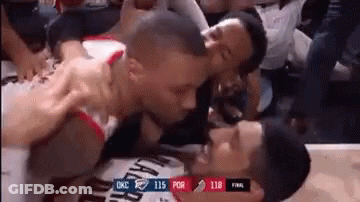 Two Basketball Players Are Kissing Each Other In The Stands . GIF