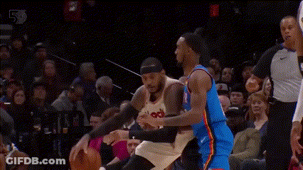 Two Basketball Players Are Playing A Game Of Basketball In Front Of A Crowd . One Player Is Wearing A Number 23 Jersey . GIF
