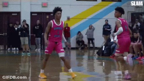Two Basketball Players Are Playing A Game Of Basketball On A Court . GIF