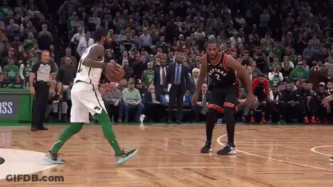 Two Basketball Players Are Playing A Game Of Basketball On A Court With A Crowd Watching . GIF
