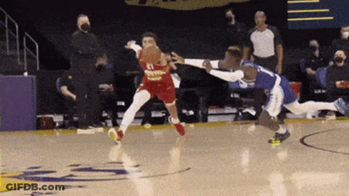 Two Basketball Players Are Playing A Game Of Basketball On A Court With A Referee In The Background . GIF