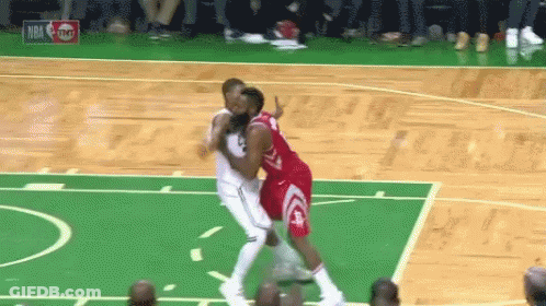 Two Basketball Players Are Playing A Game Of Basketball On A Green Court . GIF
