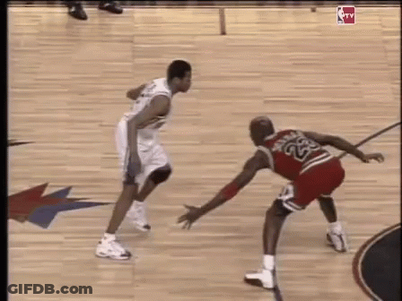 Two Basketball Players Are Playing A Game On A Court . GIF