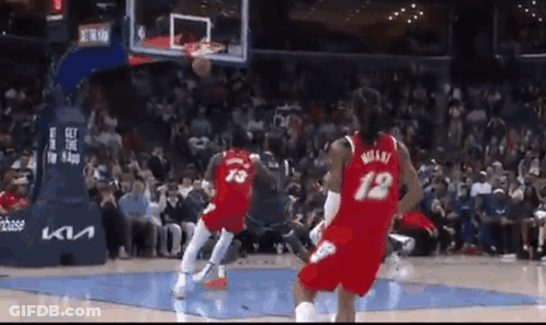 Two Basketball Players Are Playing Basketball On A Court . GIF