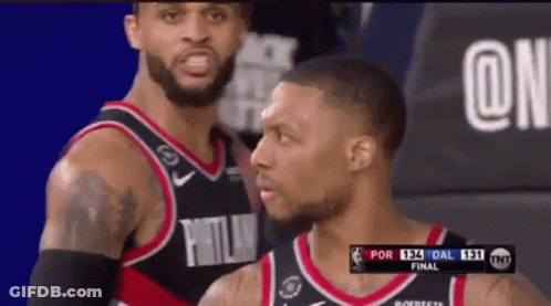 Two Basketball Players Are Standing Next To Each Other In A Basketball Game . GIF
