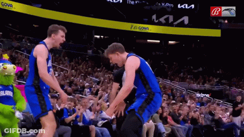 Two Basketball Players Are Standing Next To Each Other In Front Of A Crowd At A Basketball Game Sponsored By Kia GIF