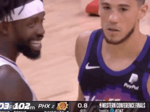 Two Basketball Players Are Talking To Each Other During A Game Sponsored By At & T GIF