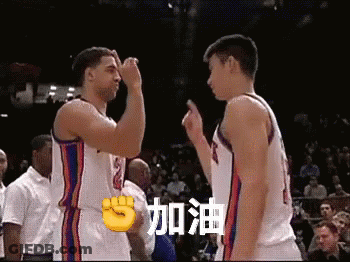 Two Basketball Players Giving Each Other A Fist Bump In Front Of A Crowd In A Stadium GIF