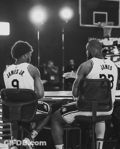 Two Basketball Players Giving Each Other A High Five With James Jr. Wearing Number 9 GIF