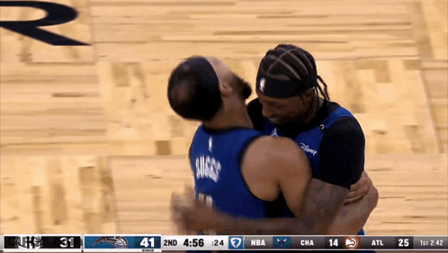 Two Basketball Players Hugging Each Other During A Game With A Score Of 41 To 24 GIF