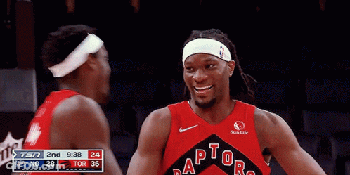 Two Basketball Players Hugging Each Other In Front Of A Sprite Sign GIF