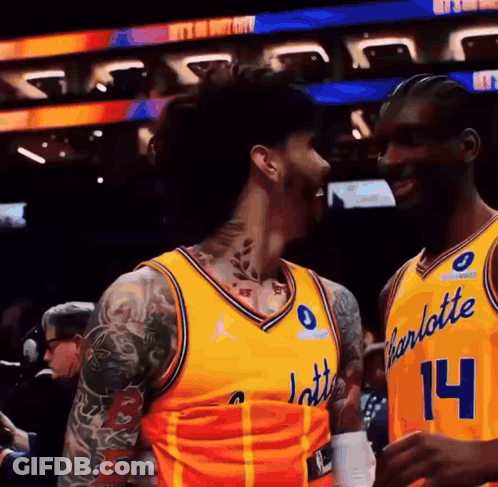Two Basketball Players In Yellow Charlotte Uniforms GIF