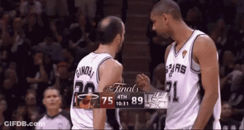 Two Basketball Players Shake Hands In Front Of A Scoreboard That Says The Finals On It GIF