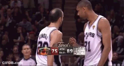 Two Basketball Players Shake Hands In Front Of A Scoreboard That Says The Finals On It GIF