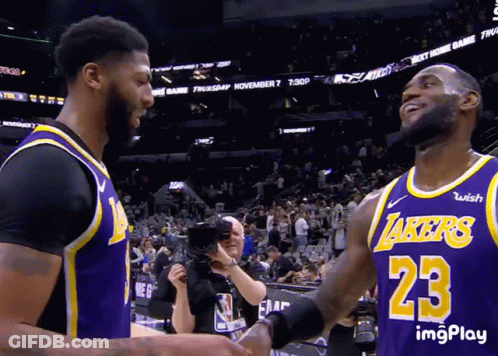 Two Basketball Players Shaking Hands With One Wearing A Lakers Jersey GIF