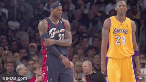 Two Basketball Players Standing Next To Each Other One Is Wearing A Lakers Jersey And The Other Is Wearing A Cleveland J GIF