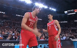 Two Basketball Players Wearing Red Jerseys With Rockets On Them Shake Hands GIF