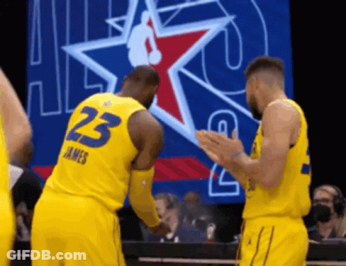 Two Basketball Players Wearing Yellow Uniforms With The Number 23 On The Back GIF