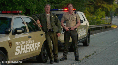 Two Beacon County Sheriffs Standing By Cars GIF