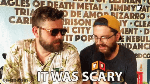 Two Bearded Men In Front Of Scary Sign GIF