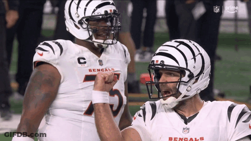 Two Bengals Football Players Are Giving Each Other A Fist Bump GIF