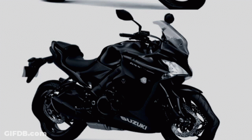 Two Black Suzuki Motorcycles Side By Side On A Gray Background GIF