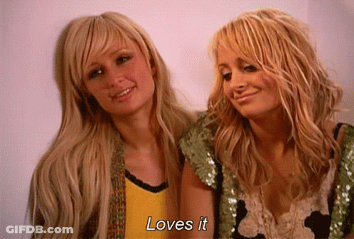 Two Blonde Women Standing Next To Each Other With The Words Loves It Written On The Bottom GIF