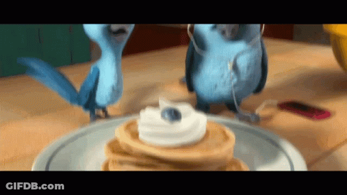 Two Blue Birds Standing Next To Pancakes With Whipped Cream GIF