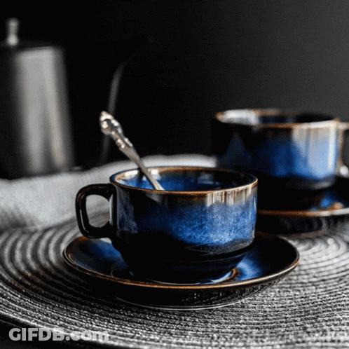 Two Blue Cups And Saucers With Silver Spoon GIF