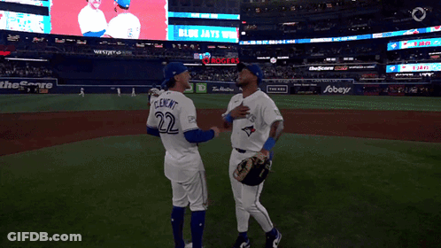 Two Blue Jays Players Talking On Baseball Field GIF