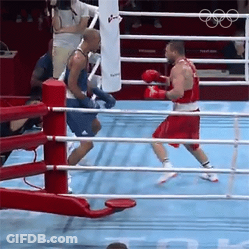 Two Boxers Are Fighting In A Boxing Ring And One Is Wearing Red Shorts GIF