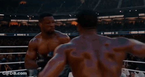 Two Boxers Are Fighting In A Ring With A Sign That Says World Heavyweight Championship In The Background GIF