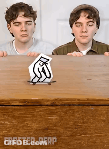 Two Boys Are Looking At A Drawing Of A Penguin On A Skateboard On A Wooden Table . GIF