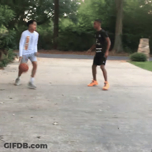 Two Boys Are Playing Basketball In A Driveway And One Of Them Has A Shirt That Says ' Lsu ' On It GIF