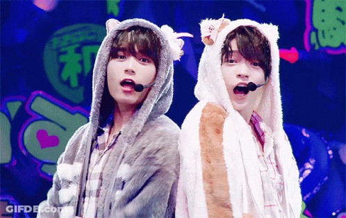 Two Boys In Furry Hooded Jackets Back To Back GIF