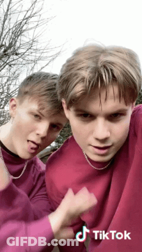 Two Boys In Purple Sweaters Making Funny Faces GIF