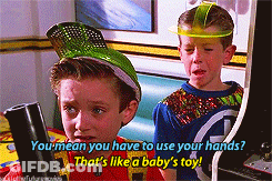 Two Boys Playing Arcade Game One In Green Hat GIF