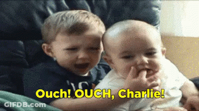 Two Boys Sitting With Words Ouch Ouch Charlie In Yellow GIF