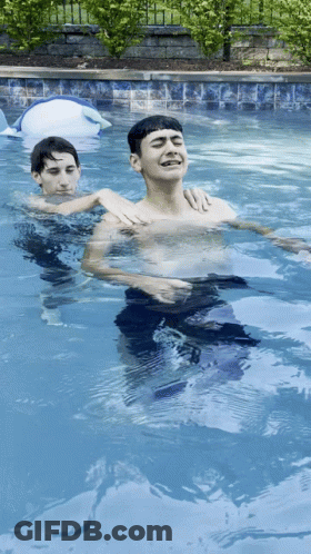 Two Boys Swimming, One Laughing In Pool GIF