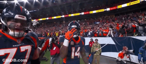 Two Broncos Football Players Standing On Field GIF