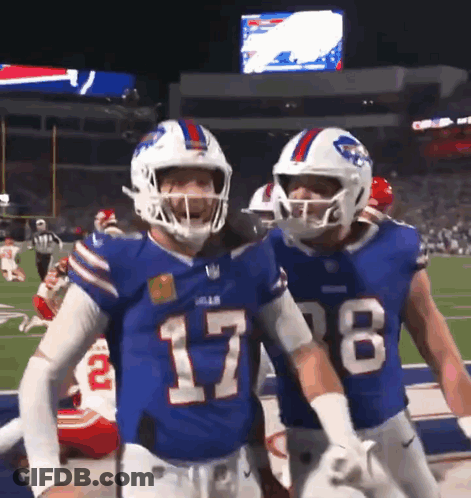Two Buffalo Bills Players Are Standing On The Field GIF