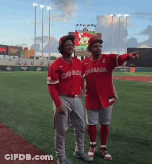 Two Canadian Baseball Players Stand On A Field GIF