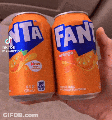 Two Cans Of Fanta Orange Soda Held In Hand GIF