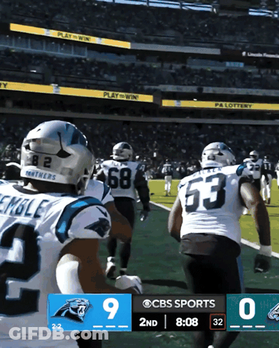 Two Carolina Panthers Players In White And Blue Uniforms GIF