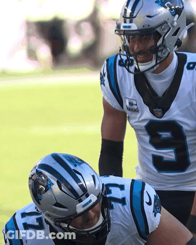 Two Carolina Panthers Players In White And Blue Uniforms GIF