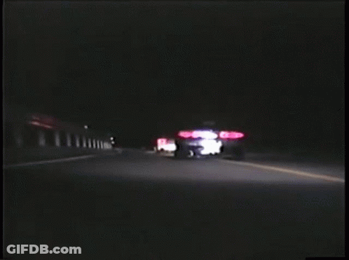 Two Cars Are Driving Down A Road At Night And One Has A License Plate That Starts With The Letter A GIF