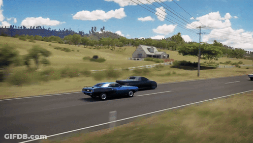 Two Cars Are Driving Down A Road In Front Of A Farm GIF