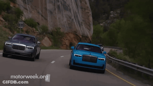 Two Cars Are Driving Down A Road With Motorweek.org In The Corner GIF